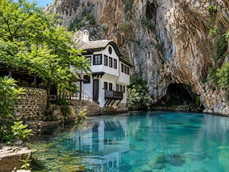 The Blagaj tekke under a tall cliff at the spring of the Buna river